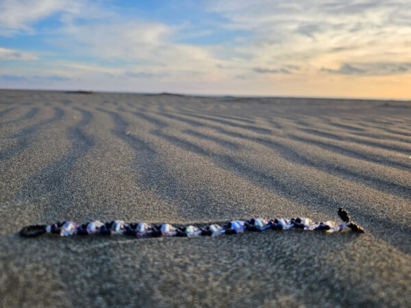 Mystical Gaze bracelet on a sand at the beach